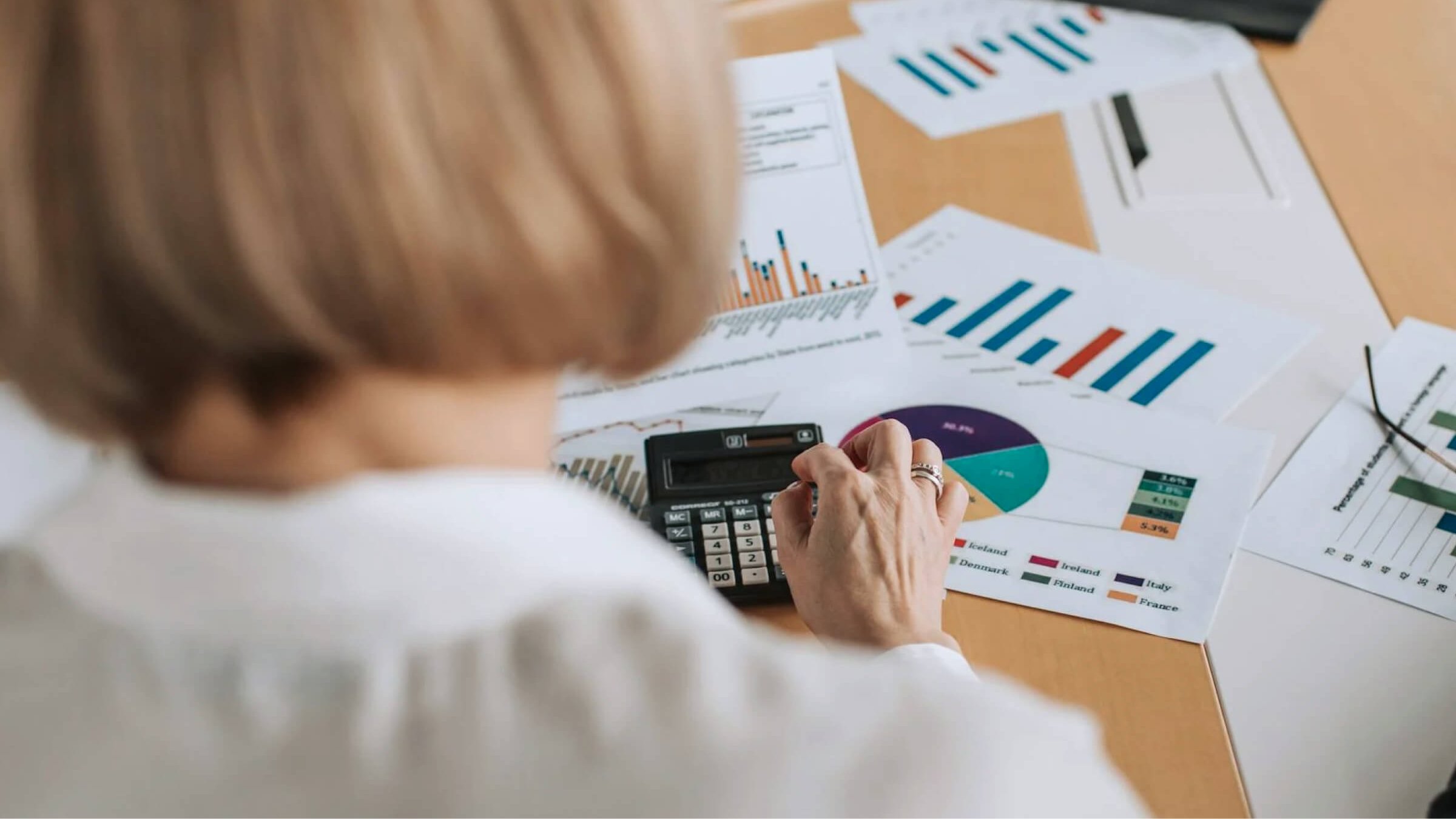 Eine Frau mit Taschenrechner und Unterlagen